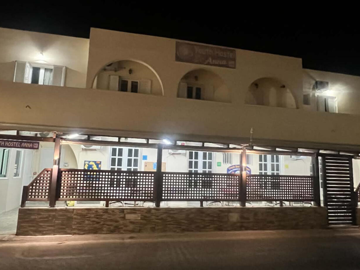 Wide night view of the illuminated Youth Hostel Anna building in Perissa