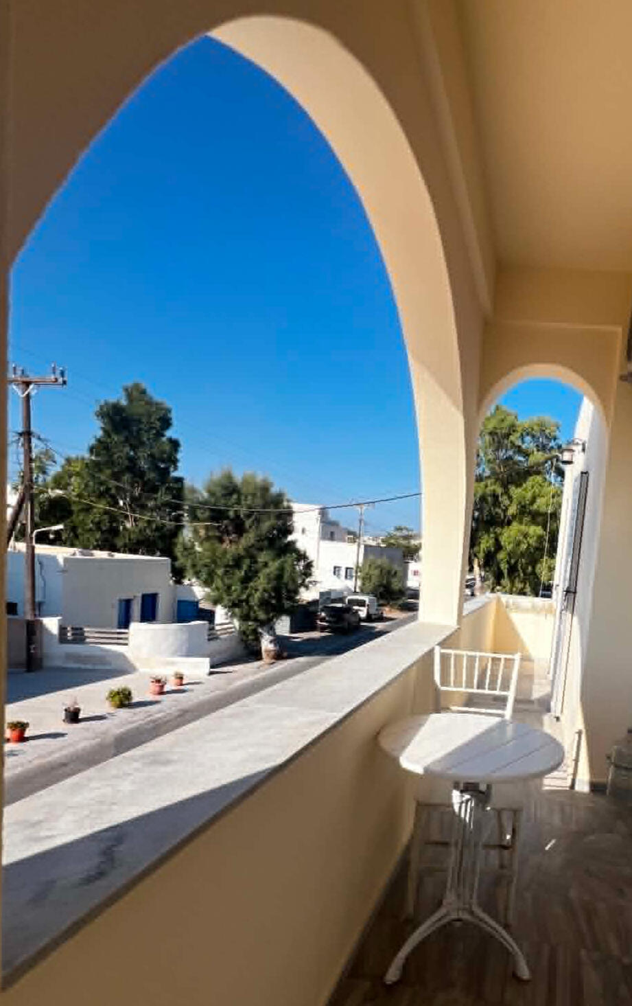 Sunny view through a Cycladic arch from a balcony at Youth Hostel Anna